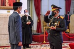 Presiden Jokowi Widodo melantik Jenderal Listyo Sigit Prabowo (kiri) sebagai Kapolri baru di Istana Presiden Jakarta, 27 Januari 2021. (Foto: Biro Setpres/AFP)