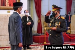 Presiden Jokowi Widodo melantik Jenderal Listyo Sigit Prabowo (kiri) sebagai Kapolri baru di Istana Presiden Jakarta, 27 Januari 2021. (Foto: Biro Setpres/AFP)