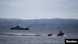 Sebuah kapal penyelamat dan kapal patroli Frontex (latar belakang) mengawal perahu migran dari Afghanistan, di pulau Lesbos, Yunani, 28 Februari 2020. (Foto: dok).