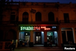 A neon sign shines above the entrance of the restaurant Prado 264, in Havana, Cuba, Feb. 15, 2018.
