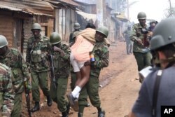 A Kenyan police officer carries a student to safety during clashes between protesters and police in the Kawangware suburb of Nairobi, Kenya, Oct. 30, 2017. A controversial presidential election re-run has triggered sporadic violence in the country.