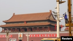 A man works on a security camera which is installed at the Tiananmen square in Beijing October 31, 2013. 