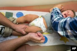 FILE - A one-year-old boy is vaccinated against measles in Northridge, California, Jan. 29, 2015.