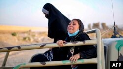 A handout picture made available by the Iranian Red Crescent on Aug. 19, 2021, shows Afghan women and children on the back of a truck at the Iran-Afghanistan border between Afghanistan and the southeastern Iranian Sistan and Baluchestan province.