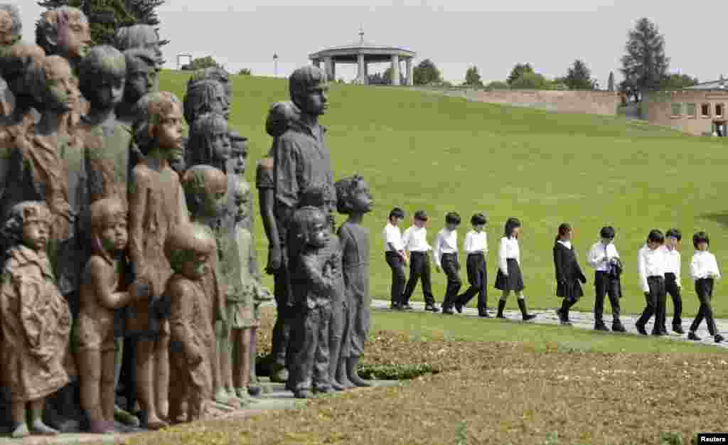 Children arrive to pay their respects at the Lidice Memorial during a remembrance ceremony honoring the 71st anniversary of the destruction of Lidice village by Germans forces, in Lidice, Czech Republic. In 1942, German troops destroyed the village in retaliation for the assassination of Reinhard Heydrich, Nazi &quot;protector&quot; of Bohemia and Moravia, by Czech resistance fighters.