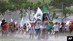 Protesters attending the Alternative World Water Forum rush to cover themselves from the rain during in Brasilia, Brazil, Thursday, March 22, 2018. The Alternative World Water Forum, held alongside the U.N.'s 8th World Water Forum, protests the privatization of water and maintains that access to water is a basic human right. (AP Photo/Eraldo Peres)