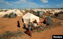 Wakimbizi wakiwa nje ya mahema yao katika kambi ya wakimbizi Ifo 2 ya Daadab karibu na mpaka wa Kenya-Somalia kaunti ya Garissa , Kenya Oct. 19, 2011.