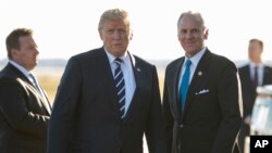 President Donald Trump stands on the tarmac with South Carolina Gov. Henry McMaster as he arrives on Air Force One at Greenville Spartanburg International Airport, in Greer, S.C., Monday, Oct. 16, 2017, en route Greenville, S.C., for a fundraiser for McMaster. 