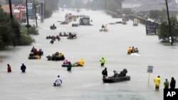 Rescue boats fill a flooded street as flood victims are evacuated as floodwaters from Tropical Storm Harvey rise, Aug. 28, 2017, in Houston.
