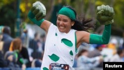 FILE - Maxine Cunningham pumps her Thing character's fists after completing the Avengers Super Heroes Half Marathon in and around the Disney Parks in Anaheim, California, Nov. 16, 2014. 
