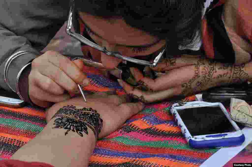 A vendor at Syria Fest offers henna tattoos, a type of body art that came from Southeast Asia, in Washington, Sept. 3, 2017. (Photo courtesy of Rabah Seba)