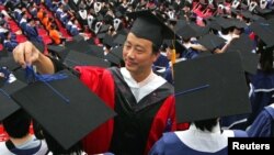 FILE: A man adjusts a student's mortar board during the graduation ceremony at Fudan University in Shanghai. Taken 6.28.2006