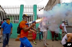 A masked protester shoots off his homemade mortar in the Monimbo neighborhood during clashes with police, in Masaya, Nicaragua, June 2, 2018.