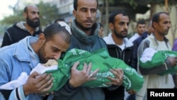 A Palestinian man kisses the body of one of his children during their funeral in the northern Gaza Strip, November 18, 2012. (Reuters)