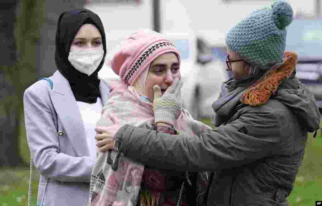 Syrian women Yasemine, center, who lost her father and brother in Syria, reacts after the verdict in front of the court in Koblenz, Germany.&nbsp;A German court has convicted Anwar Raslan, a former Syrian secret police officer, of crimes against humanity for overseeing the abuse of detainees at a jail near Damascus a decade ago.