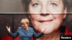 FILE - German Chancellor Angela Merkel and leader of the Christian Democratic Union party CDU stands in front of her election campaign tour bus before a CDU board meeting in Berlin.