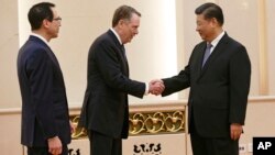 FILE - U.S. Trade Representative Robert Lighthizer, center, shakes hands with Chinese President Xi Jinping next to U.S. Treasury Secretary Steven Mnuchin, left, before their meeting at the Great Hall of the People in Beijing.