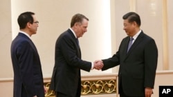 FILE - U.S. Trade Representative Robert Lighthizer shakes hands with Chinese President Xi Jinping next to U.S. Treasury Secretary Steven Mnuchin, left, before their meeting at the Great Hall of the People in Beijing, Feb. 15, 2019..