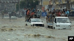 Pakistani commuters travel on a flooded street following a heavy rainfall in Karachi, Pakistan, Thursday, Aug. 31, 2017.
