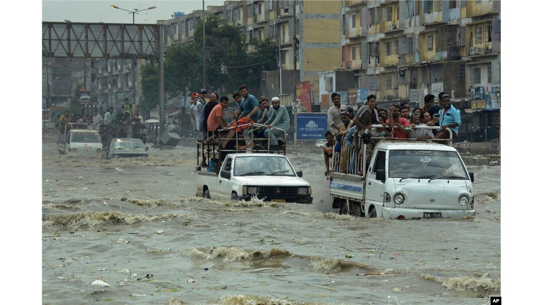 Pakistani commuters travel on a flooded street following a heavy rainfall in Karachi, Pakistan, Thursday, Aug. 31, 2017.