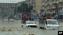 Commuters travel on a flooded street following a heavy rainfall in Karachi, Pakistan, Aug. 31, 2017.