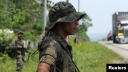 Soldiers stand guard at a checkpoint along the highway in Santa Ana May 17, 2011. Gangs and waves of drug- and arms-related violence have become major security challenges to Central American democracies.