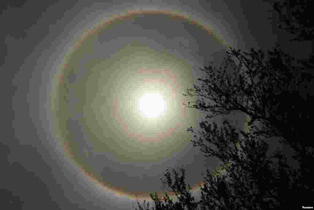 An atmospheric phenomenon known as a &quot;sun dog&quot; is seen in La Paz, El Salvador, June 26, 2013. The rare halo around the sun is caused by the refraction of sunlight by small ice crystal in the atmosphere.