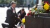 Ukraine's President Petro Poroshenko (L) and parliament speaker Volodymyr Groisman lay flowers by the photo of a police officer who was killed in violent clashes Monday, in front of Parliament in Kyiv, Ukraine, Sept. 1, 2015. 