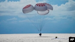 In this image provided by SpaceX, a capsule carrying four people parachutes into the Atlantic Ocean off the Florida coast, Sept. 18, 2021.