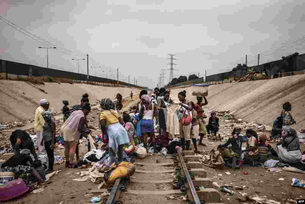 Hawkers sell their products in an improvised market across a train track in the Viana district in Luanda, Angola.