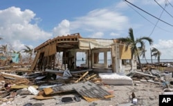 FILE - Debris surrounds a destroyed structure in the aftermath of Hurricane Irma in Big Pine Key, Fla. Rising sea levels and fierce storms have failed to stop relentless population growth along U.S. coasts in recent years, a new Associated Press analysis