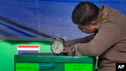 A Thai officer checks a clock to commence voting at a polling station in Bangkok, Thailand, March 24, 2019. Thailand's first general election since the military seized power in a 2014 coup has begun.