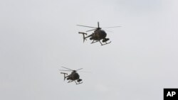 FILE - U.S.-made MD-530 helicopters, like the ones used by the Afghan Air Force, fly over Kabul, Afghanistan, Feb. 11, 2016. 