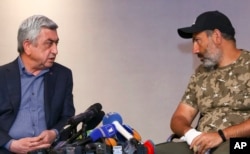 Serzh Sargsyan, left, speaks with protest leader Nikol Pashinian during their meeting in Yerevan, Armenia, April 22, 2018. (Hrant Khachatryan/PAN Photo via AP)