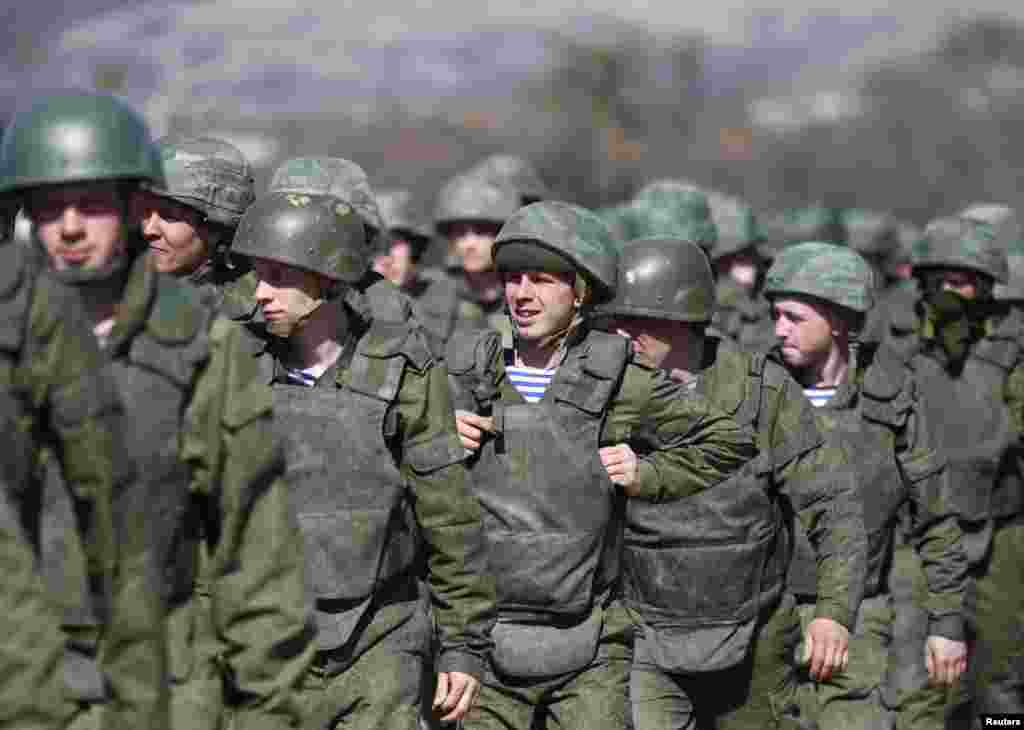 Pria-pria berseragam tanpa atribut, yang diduga kuat merupakan anggota pasukan Rusia, berbaris di luar markas militer di Perevalnoye, dekat kota Krimea, Simferopol, 21 Maret 2014.