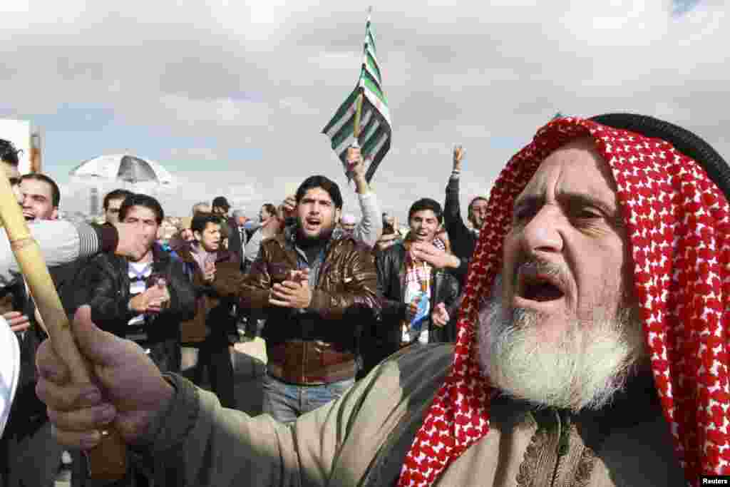 Syrian protesters living in Jordan hold Syrian opposition flags as they shout slogans against Syria's President Bashar al-Assad during a protest outside the Syrian embassy in Amman December 14, 2012. REUTERS/Muhammad Hamed (JORDAN - Tags: POLITICS CIVIL U