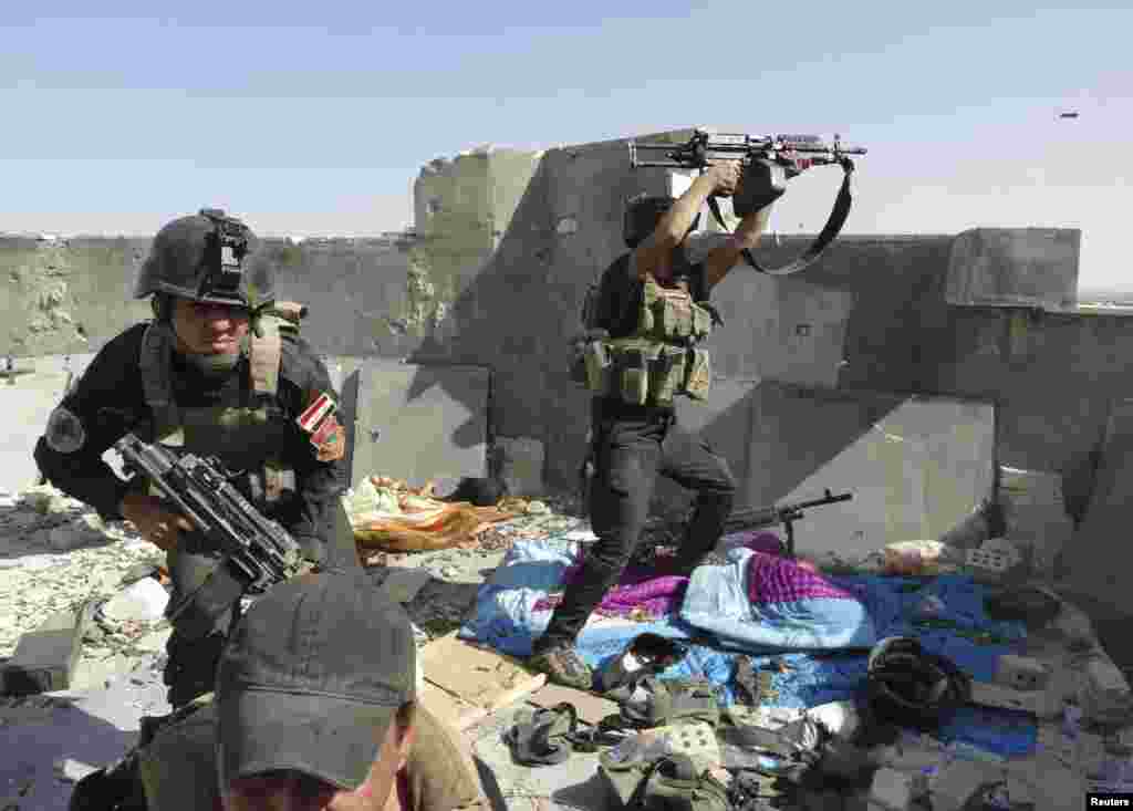 Members of the Iraqi Special Operations Forces take their positions during clashes with the Islamic State of Iraq and the Levant in Ramadi, Iraq, June 19, 2014.