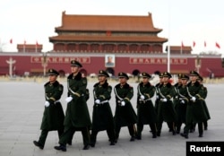 FILE - Paramilitary police walk in formation across Tiananmen Square as the sessions of the National People's Congress are taking place in the nearby Great Hall of the People in Beijing, China, March 6, 2017.