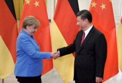 រូបឯកសារ៖ ប្រធានាធិបតីចិនលោក Xi Jinping ស្វាគមន៍អធិការបតី​អាល្លឺម៉ង់លោកស្រី Angela Merkel នៅវិមានរដ្ឋាភិបាលចិននៅទីក្រុងប៉េកាំងប្រទេសចិន កាលពីថ្ងៃទី ២៤ ខែឧសភា ឆ្នាំ២០១៨។