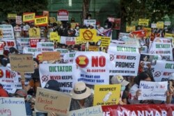 Pengunjuk rasa anti kudeta memegang plakat di dekat Kedutaan Besar Indonesia (KBRI) di Yangon, Myanmar, Rabu, 24 Februari 2021. (AP Photo)