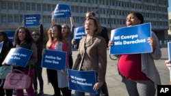 FILE - Activists with Planned Parenthood demonstrate in support of a pregnant 17-year-old being held in a Texas facility for unaccompanied immigrant children, outside the Department of Health and Human Services in Washington, Oct. 20, 2017. Two such teens eventually received access to abortions.
