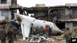 Des soldats observent autour des débris de l'avion-cargo Fokker 50 qui s'est écrasé à l'aéroport international Kenyatta de Nairobi, au Kenya, le 2 juillet 2014. 