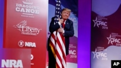 Tổng thống Trump ôm quốc kỳ Mỹ hôm 2/3.