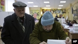 An elderly couple vote at a polling station in central Moscow, Russia, March 4, 2012.
