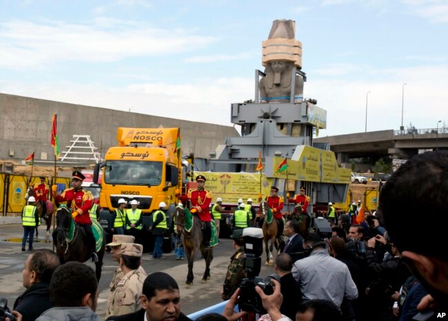 FILE - The statue of Egyptian Pharaoh Ramses II is                surrounded by honor guards as it is moved to its permanent                home at the Grand Egyptian Museum in Cairo, Egypt, Jan.                25, 2018.