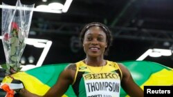 FILE - Elaine Thompson of Jamaica celebrates her bronze medal finish in the women's 60 meters final during the IAAF World Indoor Athletics Championships in Portland, Oregon, March 19, 2016.