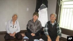 Han Bok-yeo (center) and her two neighbors from Seo-Yeonpyeong Island sit together in their apartment in Gimpo, South Korea