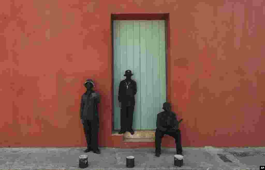 Street performers act as statues outside a home in the historical center of Cartagena, Colombia. Cartagena is hosting the 25th Ibero-American Summit, an annual meeting of heads of state from Latin America and the Iberian Peninsula.