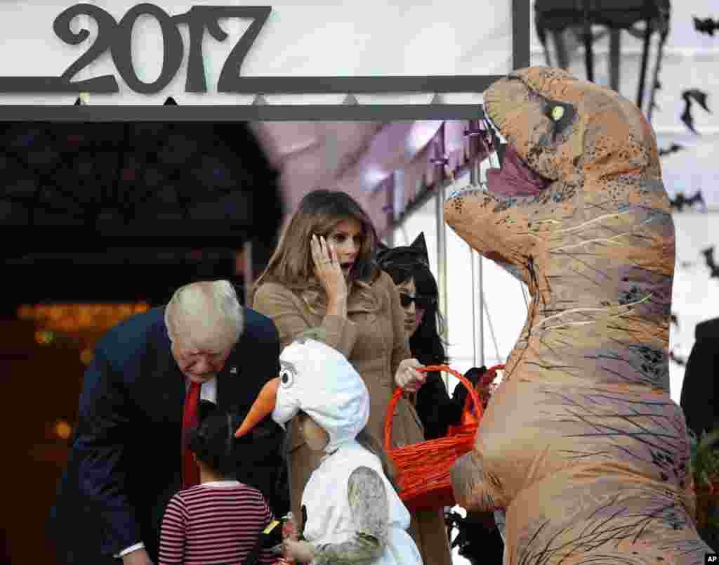 President Donald Trump and first lady Melania Trump hand out treats as they welcome children from the Washington area and children of military families celebrating Halloween, Oct. 30, 2017.