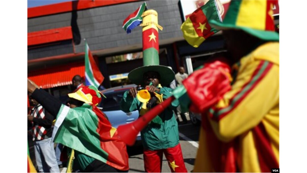Para pendukung Kamerun meniupkan instrumen khas Afrika Selatan, 'vuvuzela,' di depan Stadion Free State di Bloemfontein.